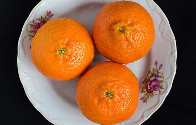 Три спелых мандарина на тарелке